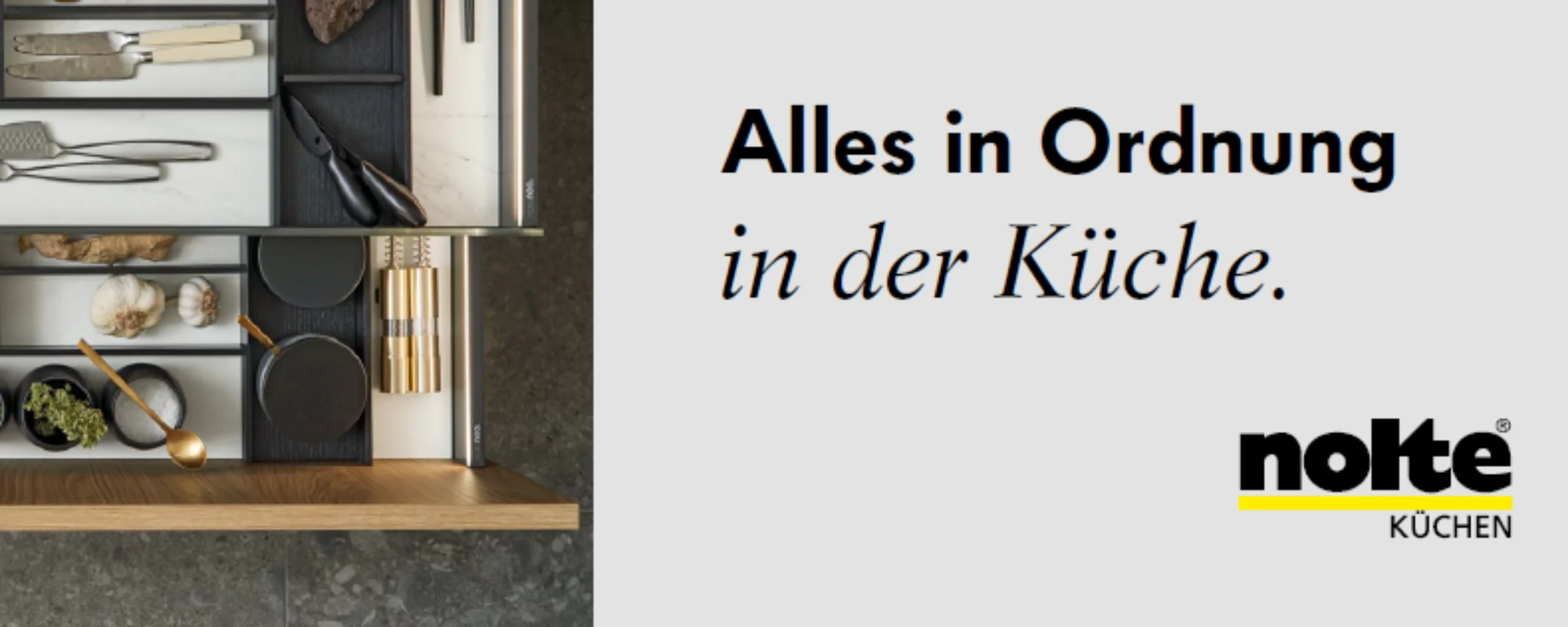 Eine geöffnete Küchenschublade zeigt sortiertes Besteck und Utensilien, perfekt organisiert mit Nolte Küchen.