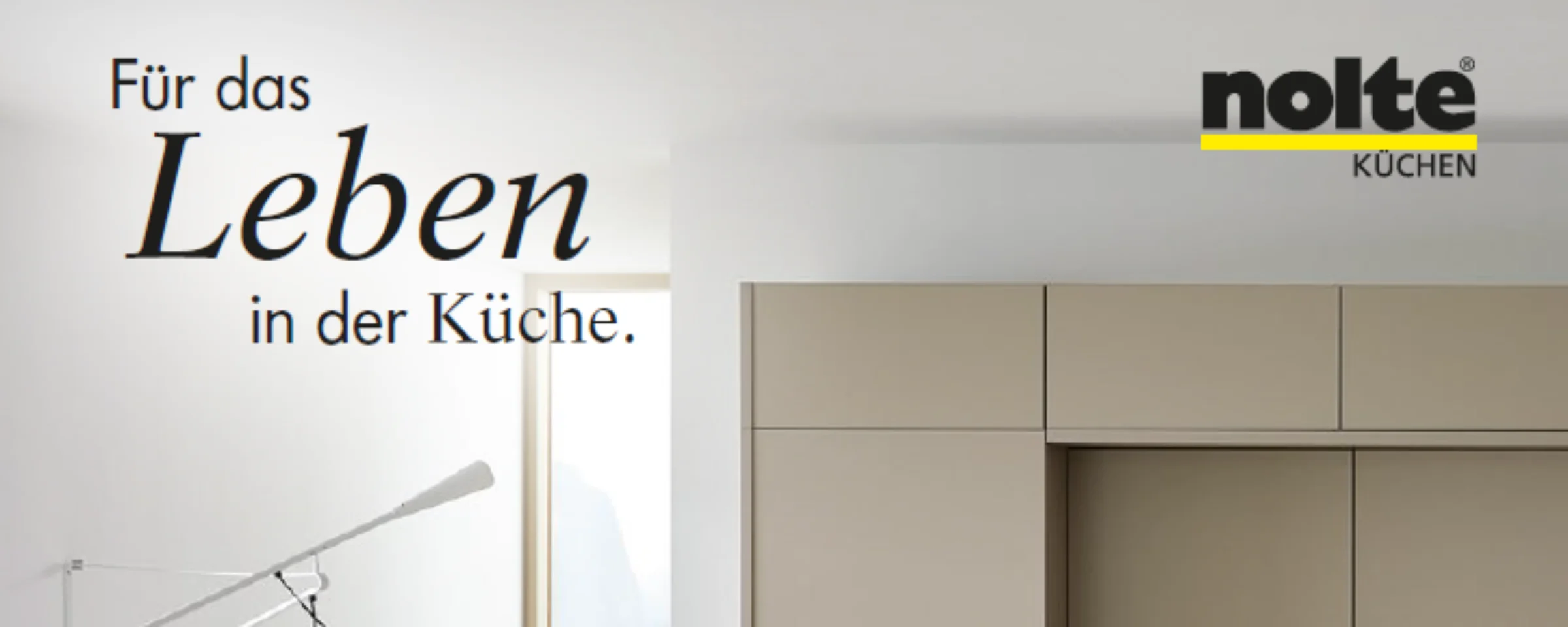 Eine moderne Küche mit hellen Schränken und einem großen Fenster, stilvoll präsentiert von Nolte Küchen.