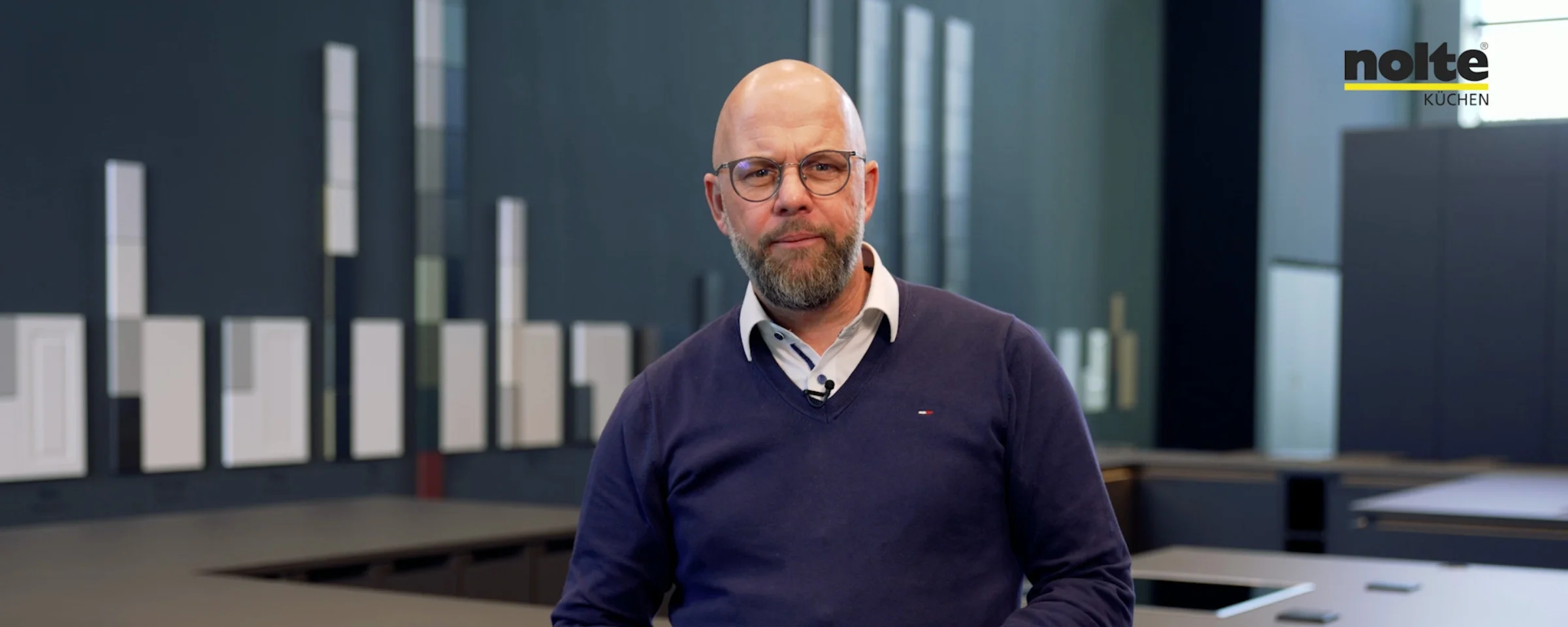 Eine moderne Küche mit einem Mann im Vordergrund, Nolte Küchen.