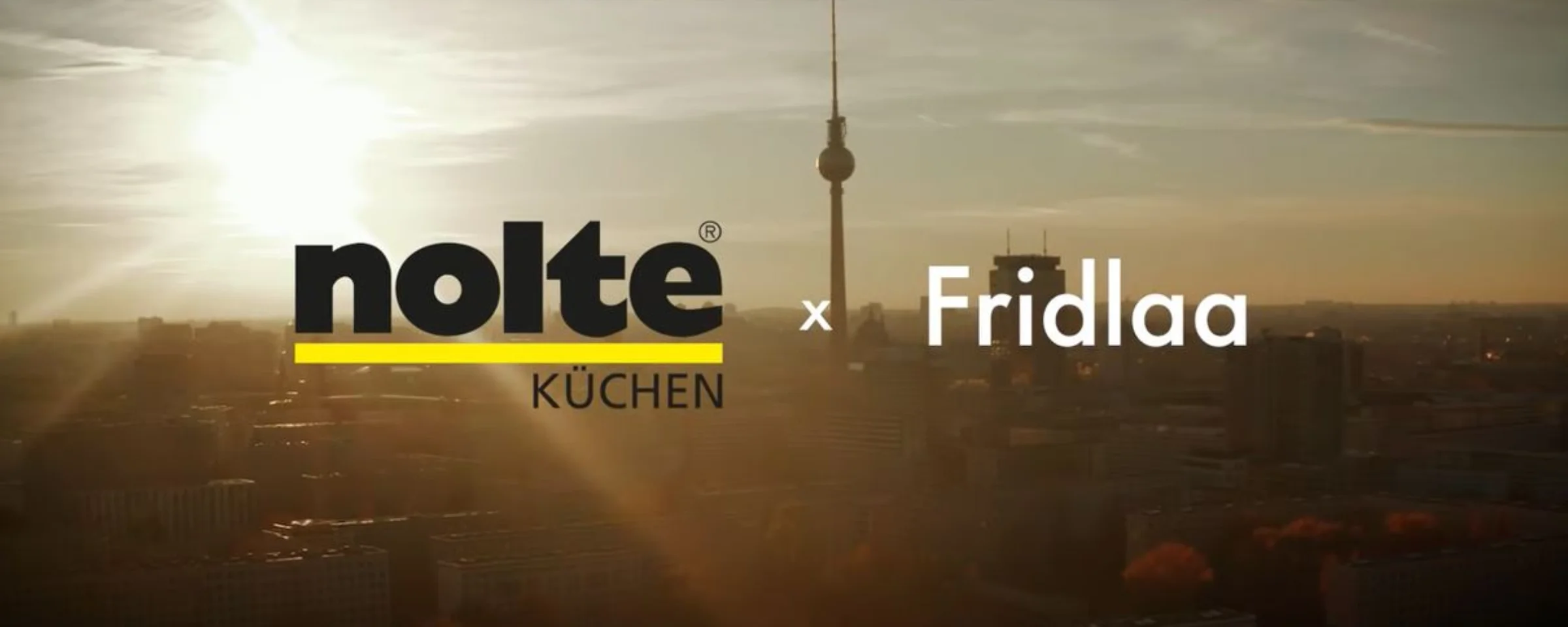 Die Skyline einer Stadt im Sonnenuntergang mit dem Fernsehturm, Nolte Küchen im Vordergrund.