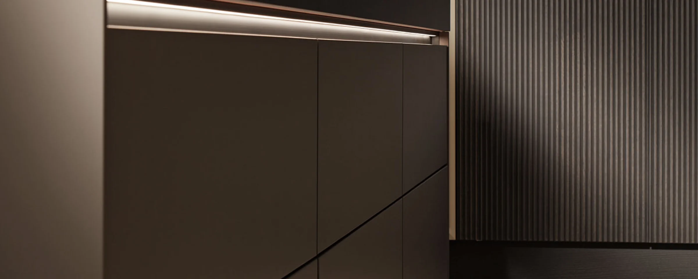 Cuisine moderne avec armoires sombres élégantes et éclairage de Nolte Kitchen.