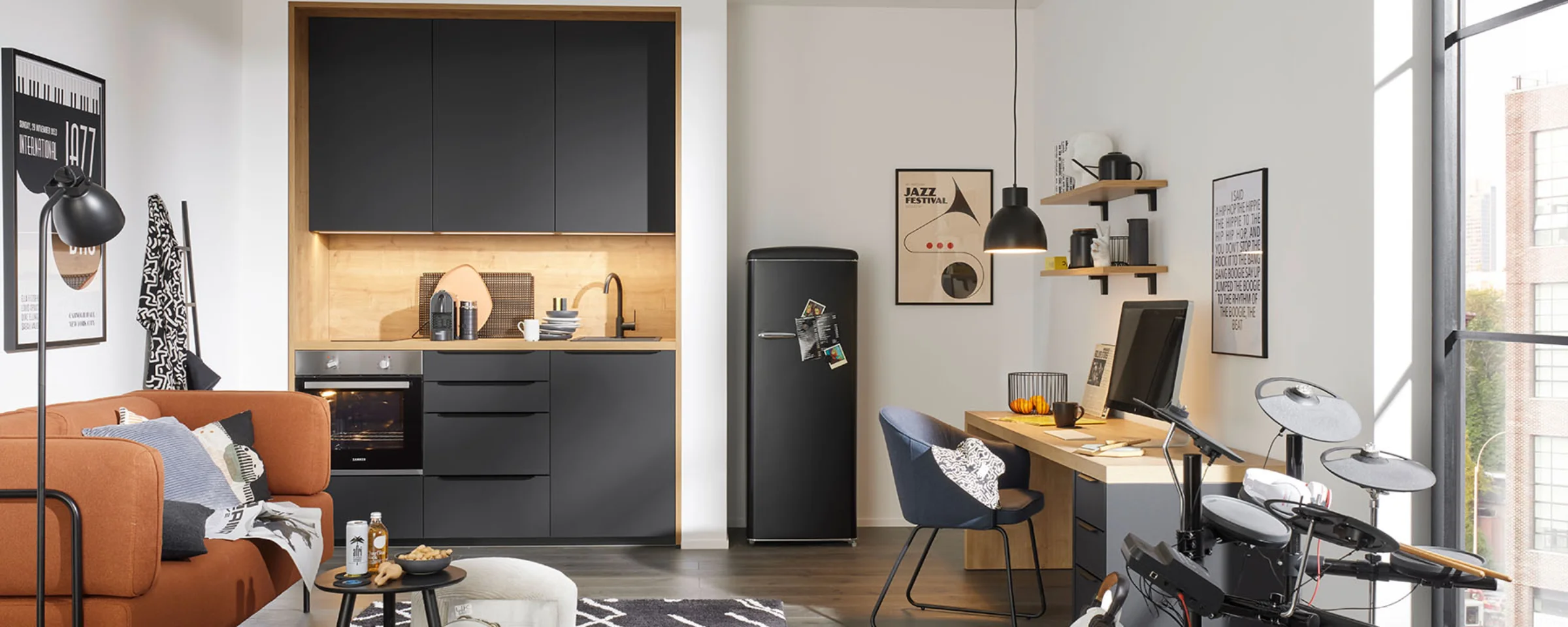 In una stanza moderna con cucina grigia di Nolte Kitchen, ci sono un divano, una scrivania e una batteria elettronica.