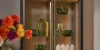 A stylish kitchen cabinet with glass shelves and decorative lighting, arranged by Nolte Kitchens.