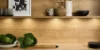 Una cocina moderna con acabado de madera, estantes y decoraciones, diseñada por Nolte Cocina.