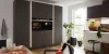 A modern kitchen with black cabinets and plenty of natural light by Nolte Kitchen.