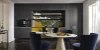 A modern kitchen with dark cabinets and a round table, designed by Nolte Kitchen.