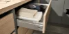 Ein geöffneter Schubladenschrank mit Handtüchern und Kleidungsstücken in einem Hauswirtschaftsraum von Nolte Hauswirtschaftsräume.