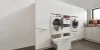 Ein moderner Hauswirtschaftsraum mit Waschmaschine und Trockner, integriert in weiße Schränke von Nolte Hauswirtschaftsräume.