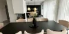 Ein elegantes Esszimmer mit modernem Tisch und Stühlen, betont durch stilvolle Beleuchtung, von Nolte Living.