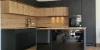Een moderne keuken met donkere en houten fronten en een kookeiland van Nolte Kitchen.