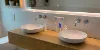 Ein modernes Badezimmer mit Doppelwaschbecken und Spiegel, dekoriert mit Pflanzen. Nolte SPA.