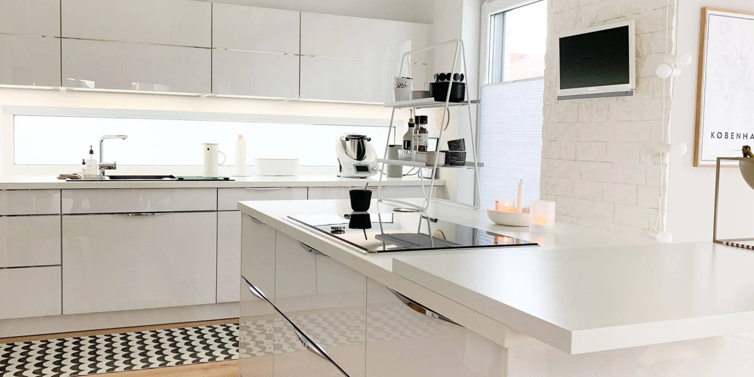 Nowoczesna kuchnia z białymi, błyszczącymi frontami i wyspą kuchenną, Nolte Kitchen.