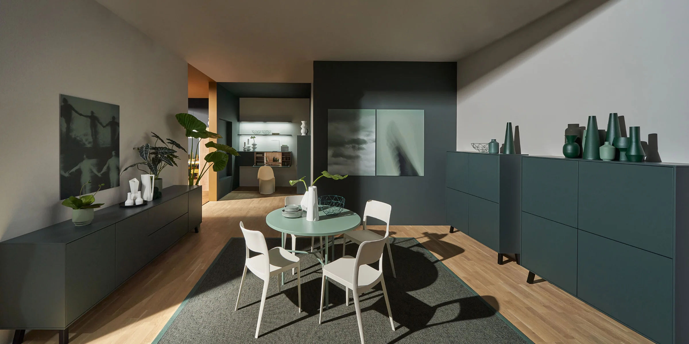 Ein moderner Wohnbereich mit Tisch und Stühlen, umgeben von stilvollen Schränken, von Nolte Living.