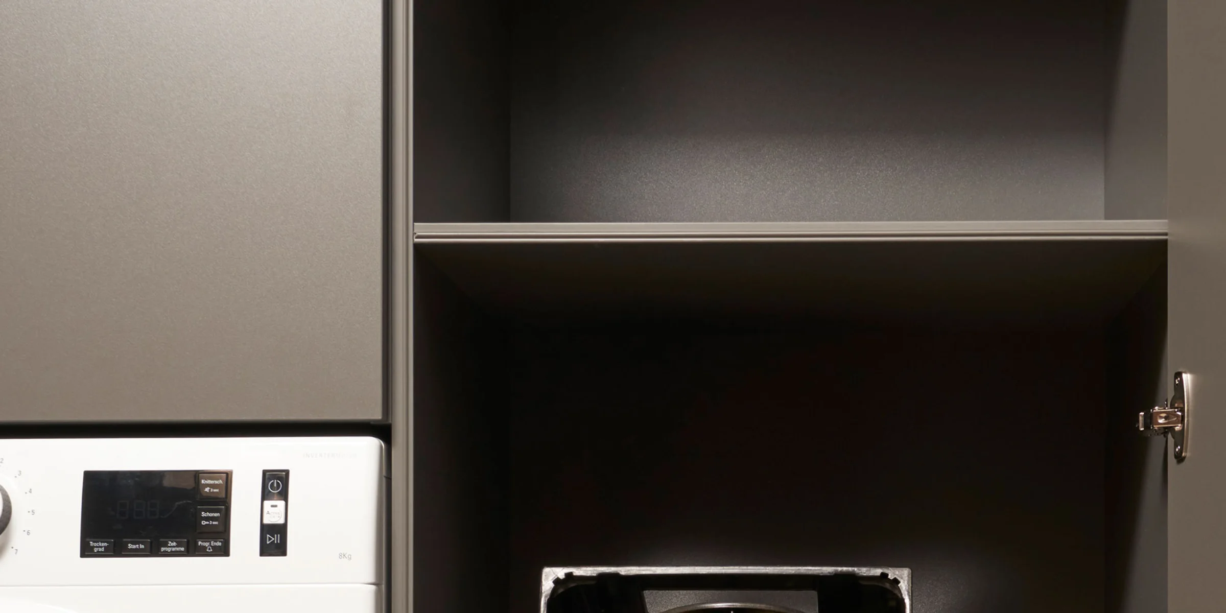 Ein Hauswirtschaftsraum mit Waschmaschine und Regalen, gestaltet von Nolte Hauswirtschaftsräume.