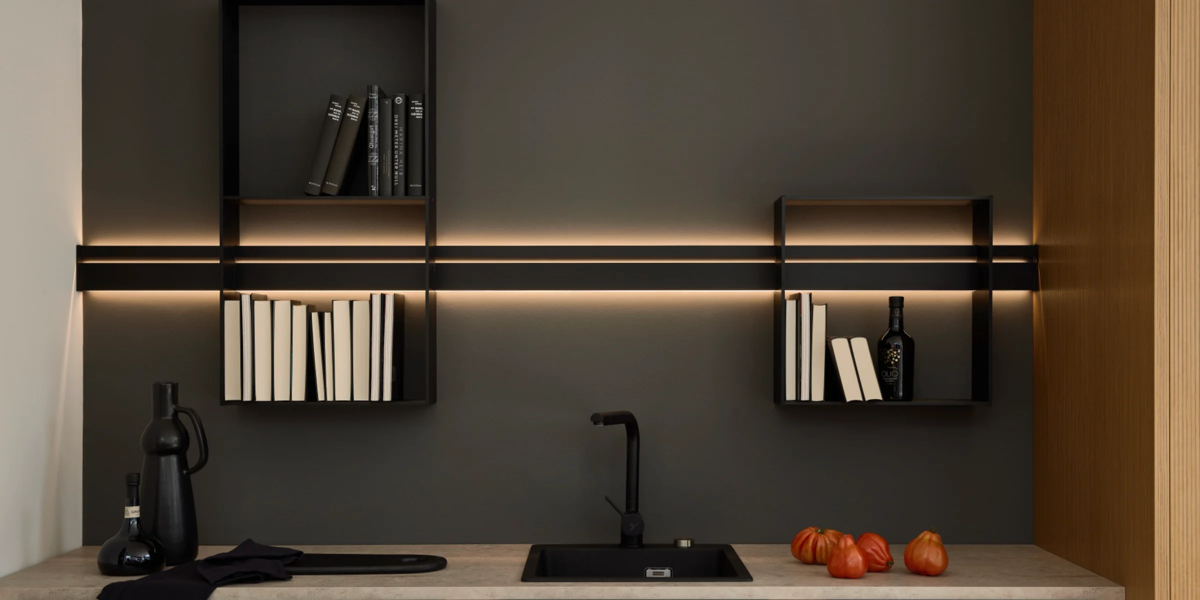 Eine moderne Küche mit dunklen Hängeregalen und LED-Beleuchtung, gestaltet von Nolte Küchen.