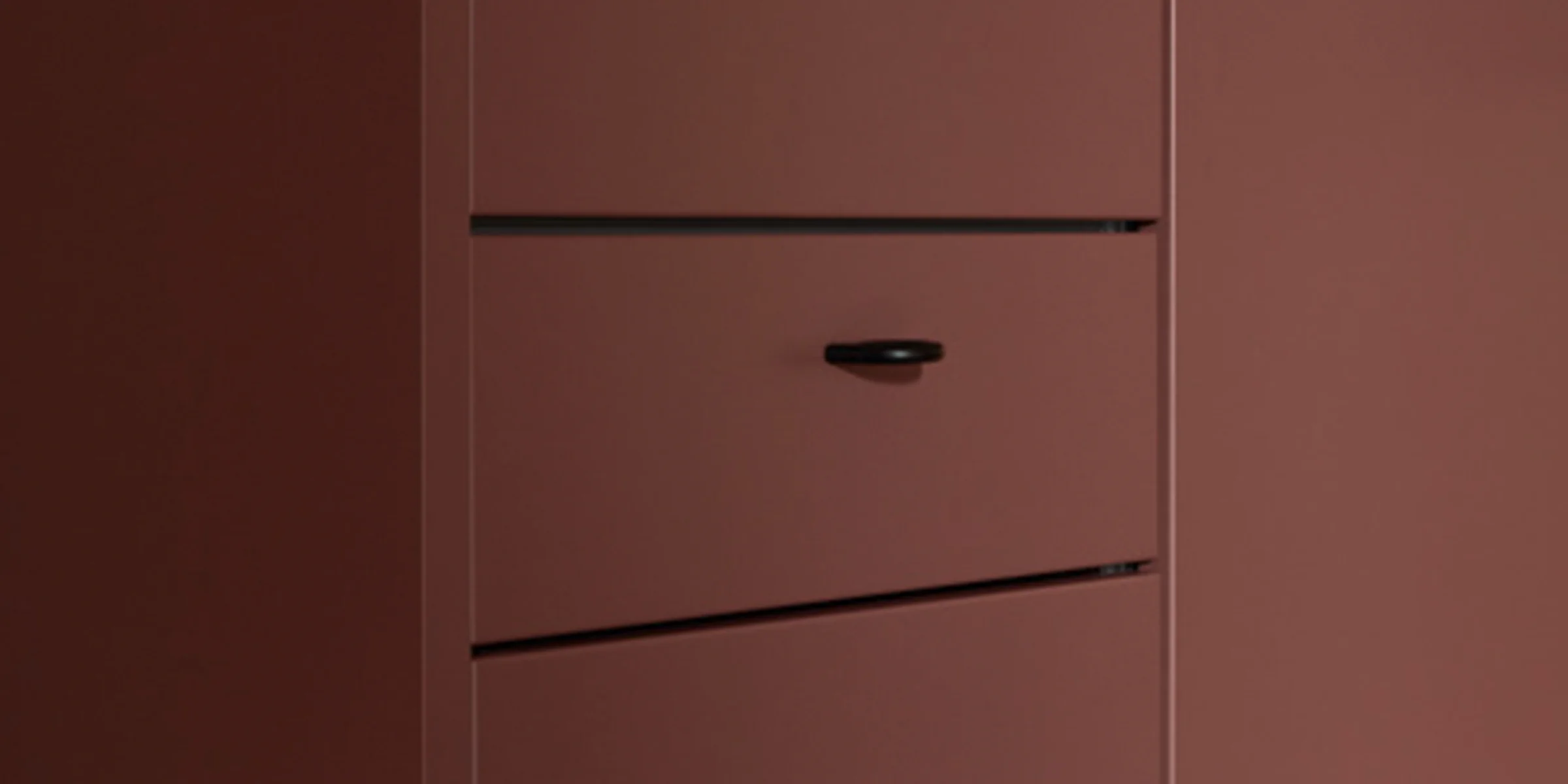 Ein modernes, rotbraunes Schrankdesign mit klaren Linien, Teil von Nolte Living.