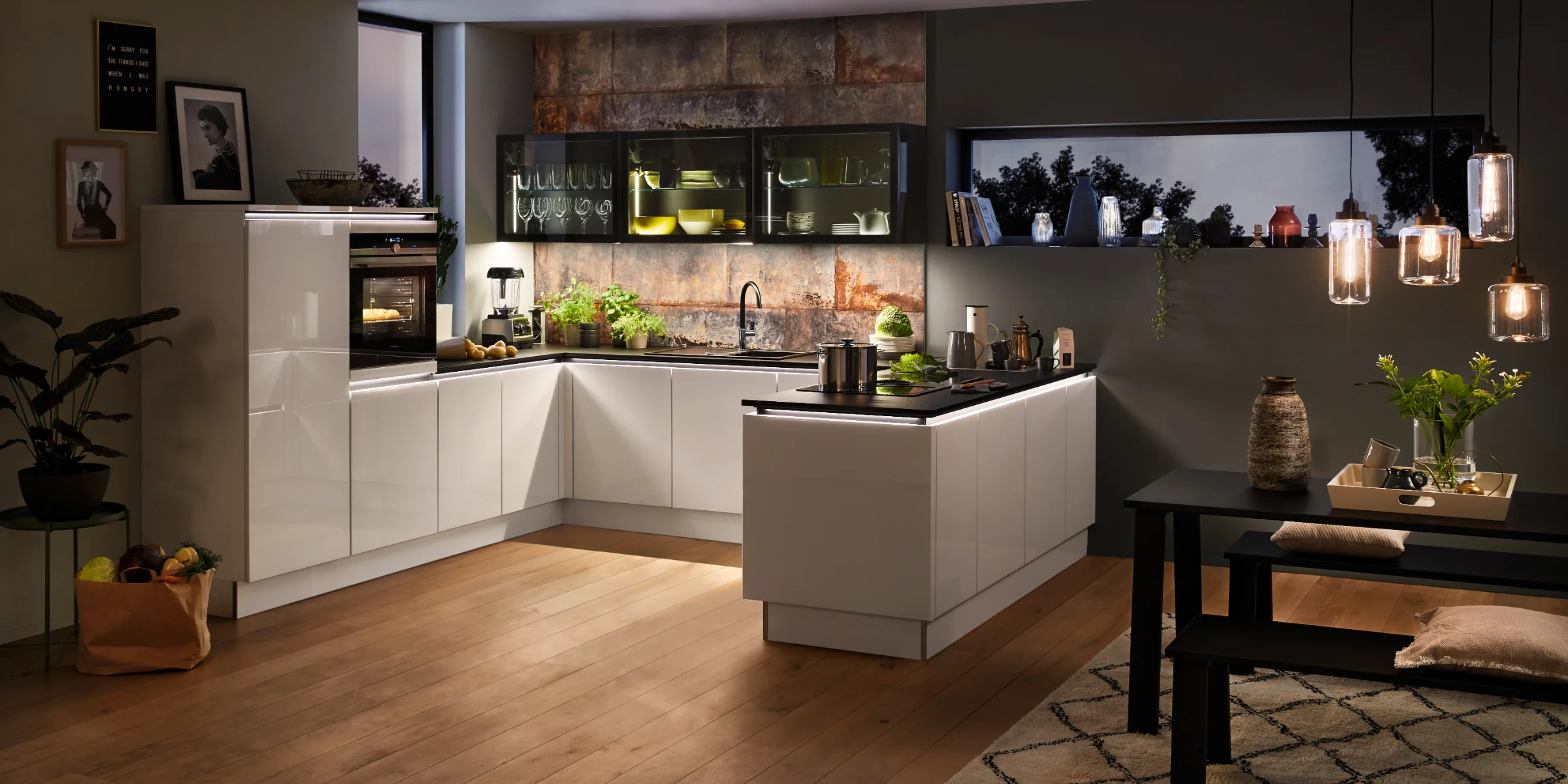 Eine moderne, stilvolle Küche mit weißen Schränken und Holzfußboden, gestaltet von Nolte Küchen.