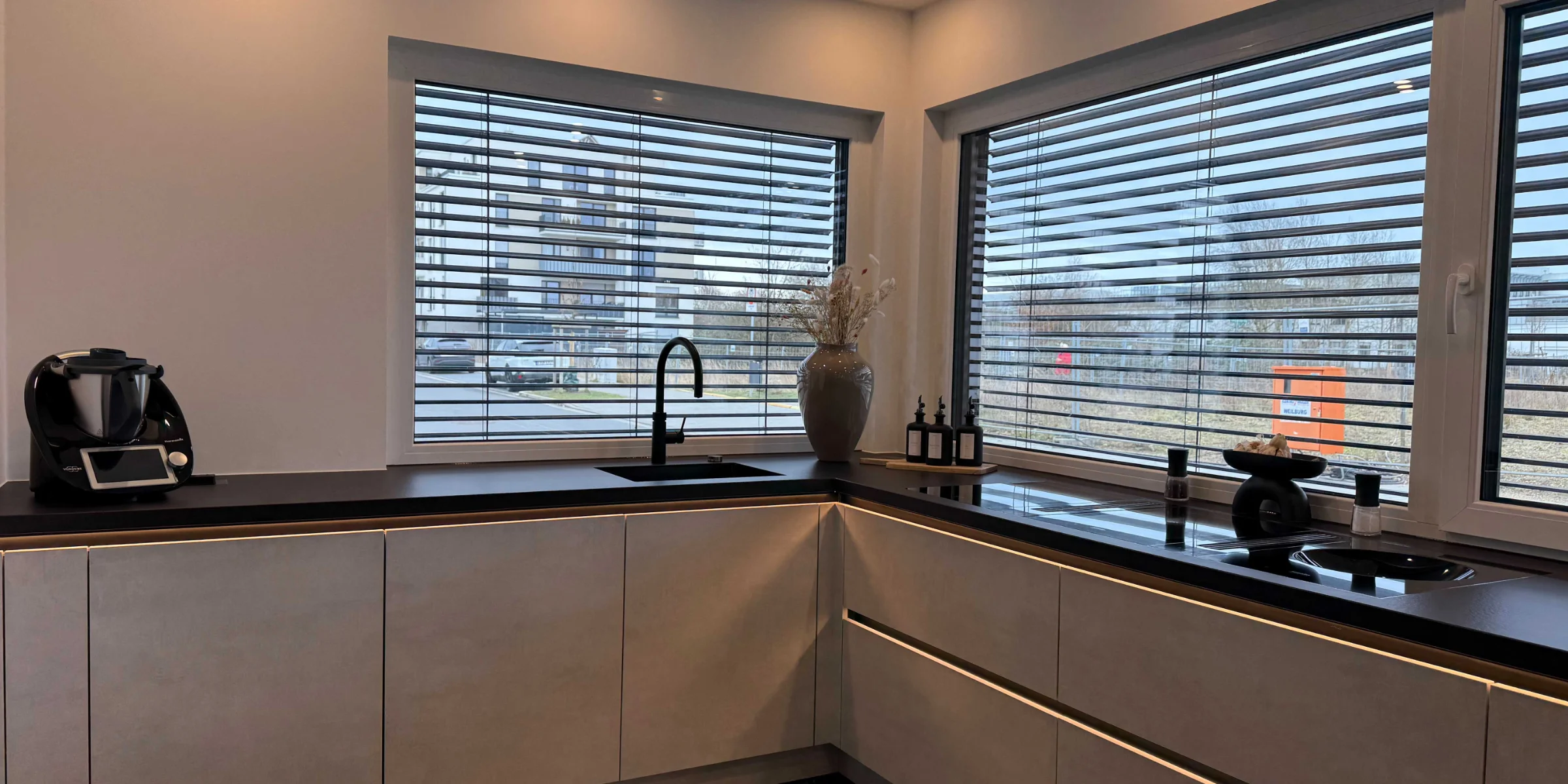 Cucina moderna con grandi finestre e eleganti piani di lavoro. Nolte Küchen.