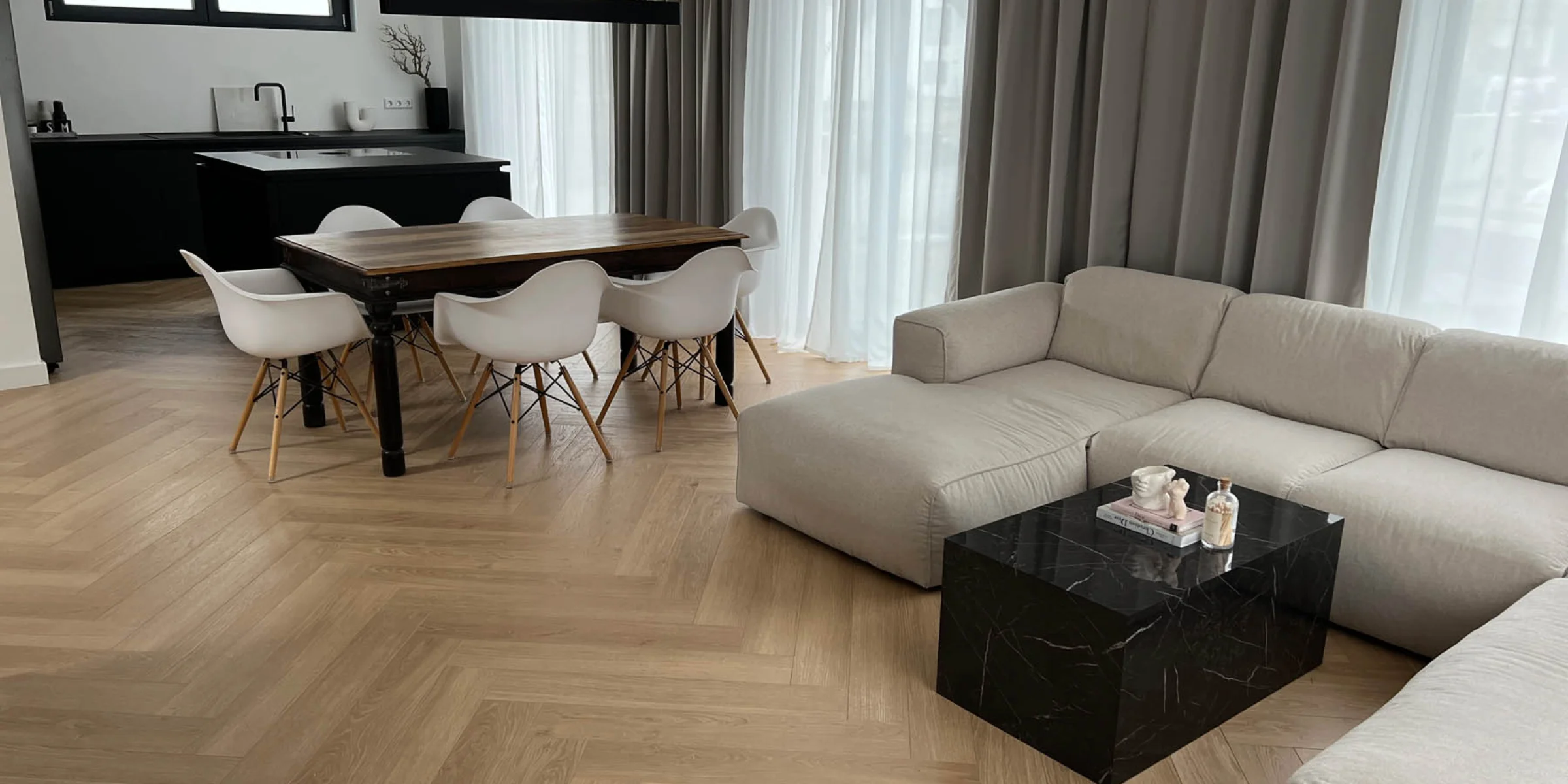 Ein modernes Wohnzimmer mit Nolte Living Möbeln und einer Küche im Hintergrund.