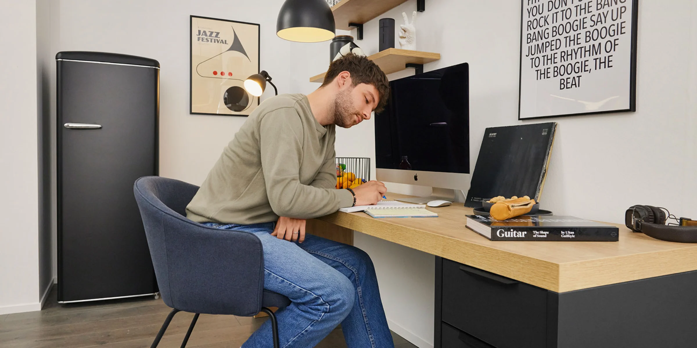 Un uomo è seduto a una scrivania in uno studio moderno con mobili di Nolte Living.
