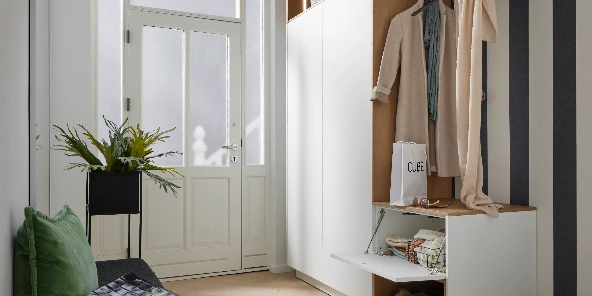 Ein stilvoll eingerichteter Eingangsbereich mit Garderobe, Sitzbank und Dekoration, passend für Nolte Living.