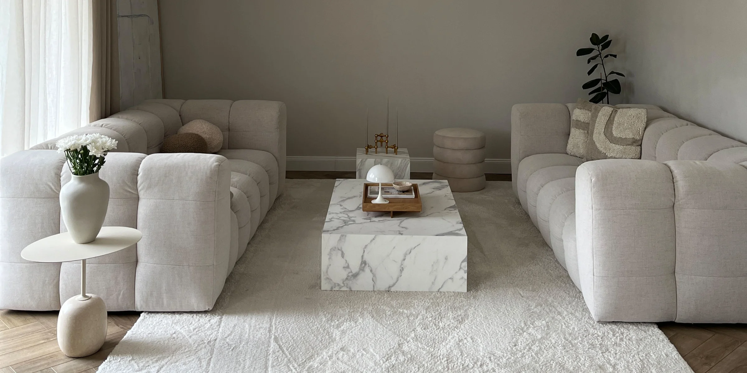 Ein modernes Wohnzimmer mit zwei Sofas und einem Marmortisch, passend zu Nolte Living.