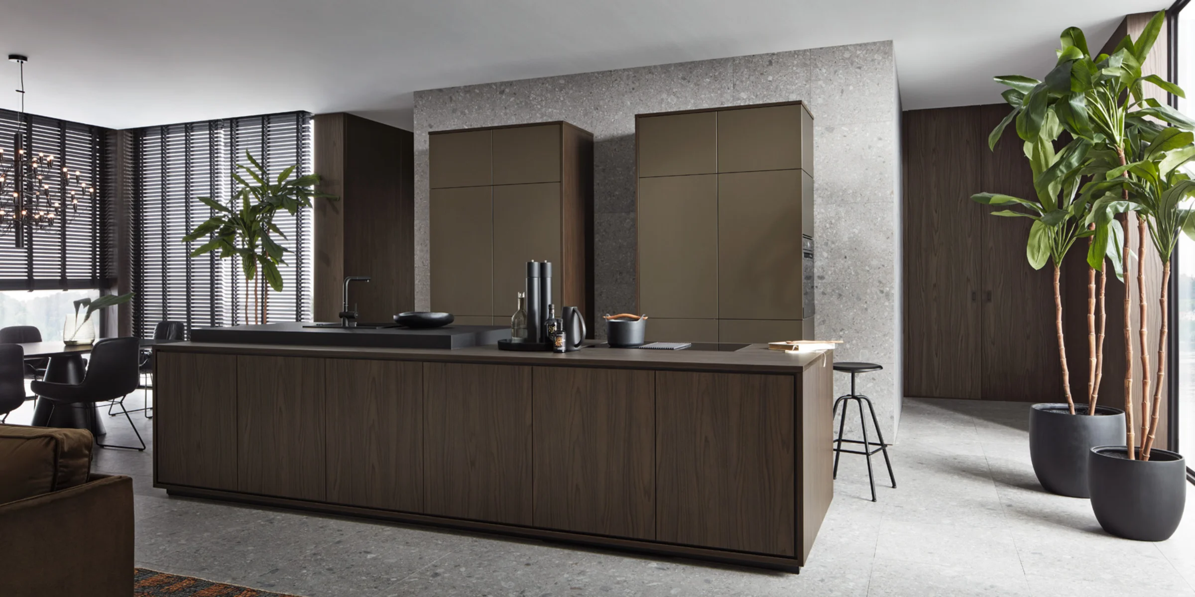 Exklusive Nolteneo Küche mit der edlen Holzfront neoLEAF in Noce Marone und der eleganten neoPURE in Metal Bronze. Die grifflose Kücheninsel zeigt fein gemaserte Echtholzoptik, während die Hochschränke in metallischem Bronzeton einen stilvollen Kontrast setzen. Das Design überzeugt durch klare Linien, hochwertige Materialien und eine luxuriöse, offene Raumwirkung.