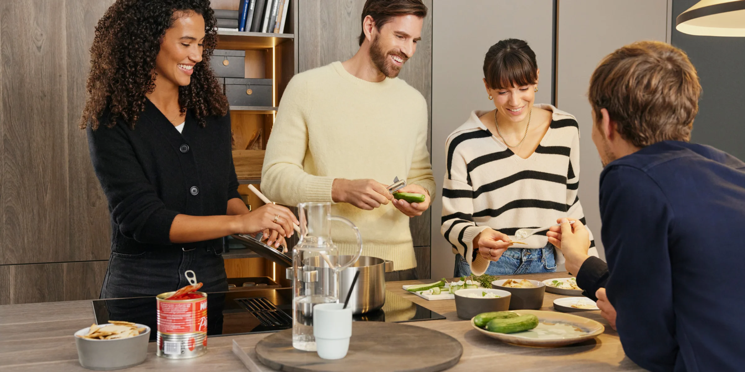 Eine Gruppe von Menschen kocht gemeinsam in einer modernen Nolte Küchen Umgebung.