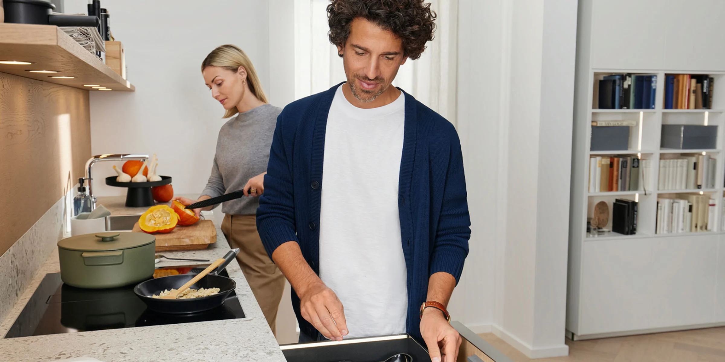 Ein Mann und eine Frau kochen gemeinsam in einer modernen Küche von Nolte Küchen.