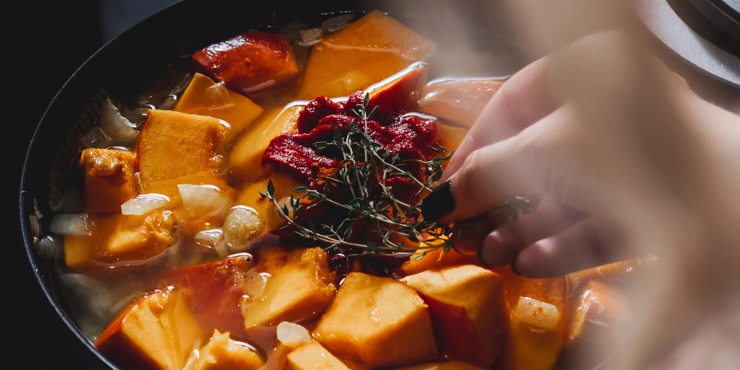 In einer Pfanne werden Kürbisstücke mit Kräutern gekocht, passend zu Nolte Küchen.
