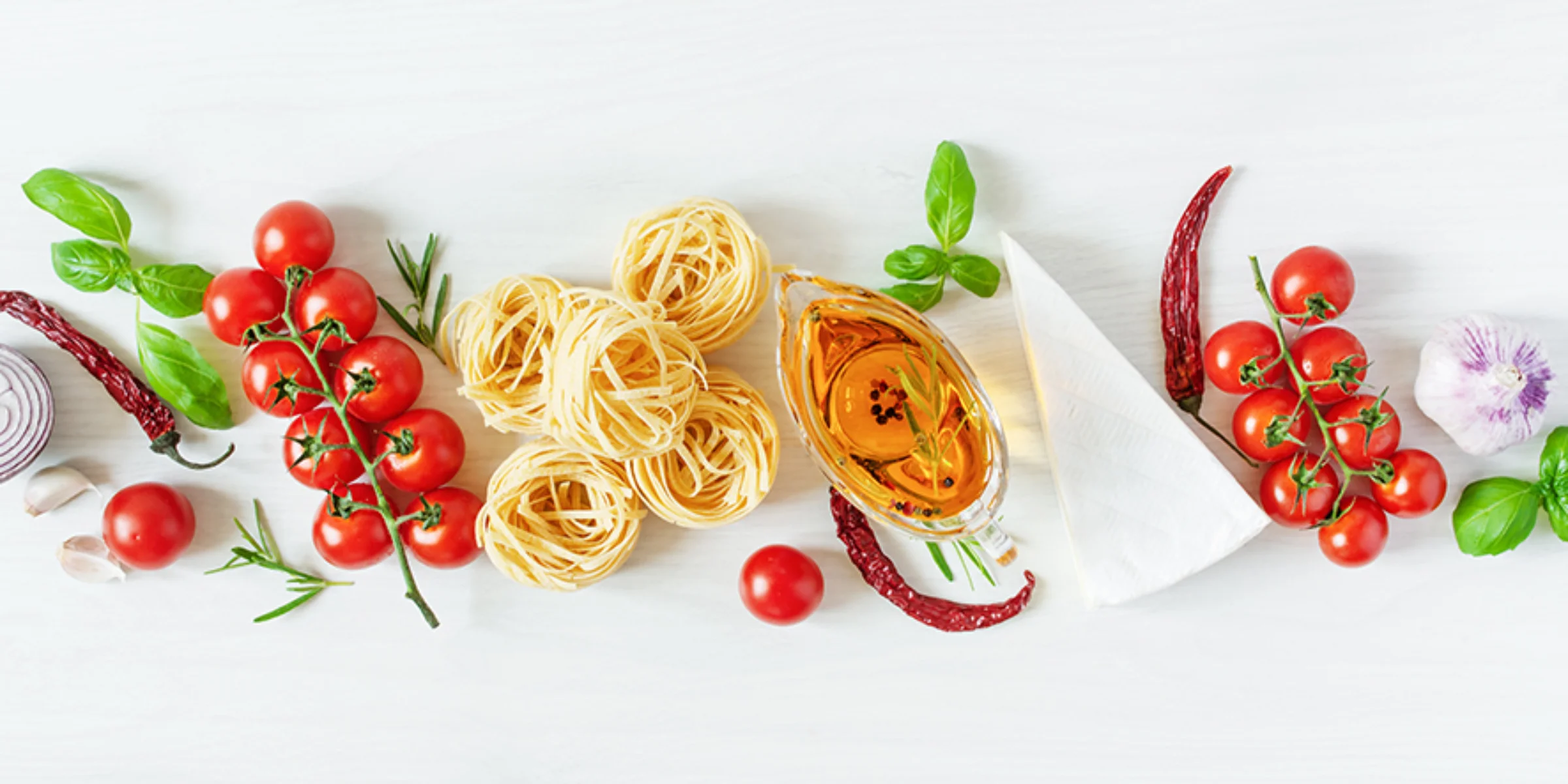 Zwei Personen bereiten gemeinsam eine Mahlzeit zu. Auf einem Küchenarbeitsplatz werden Gemüse geschnitten und ein Salat gemischt.