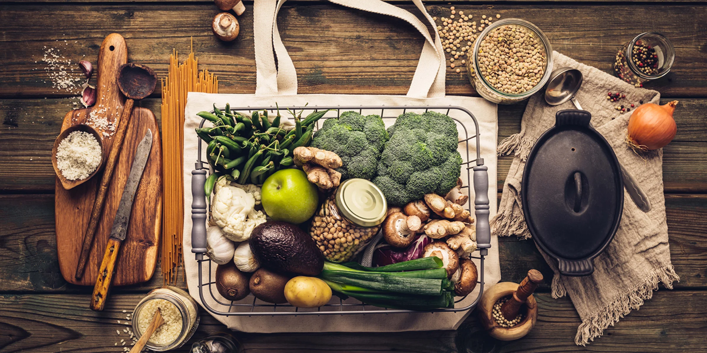 Eine Auswahl an frischem Gemüse und Zutaten liegt auf einem Holztisch.