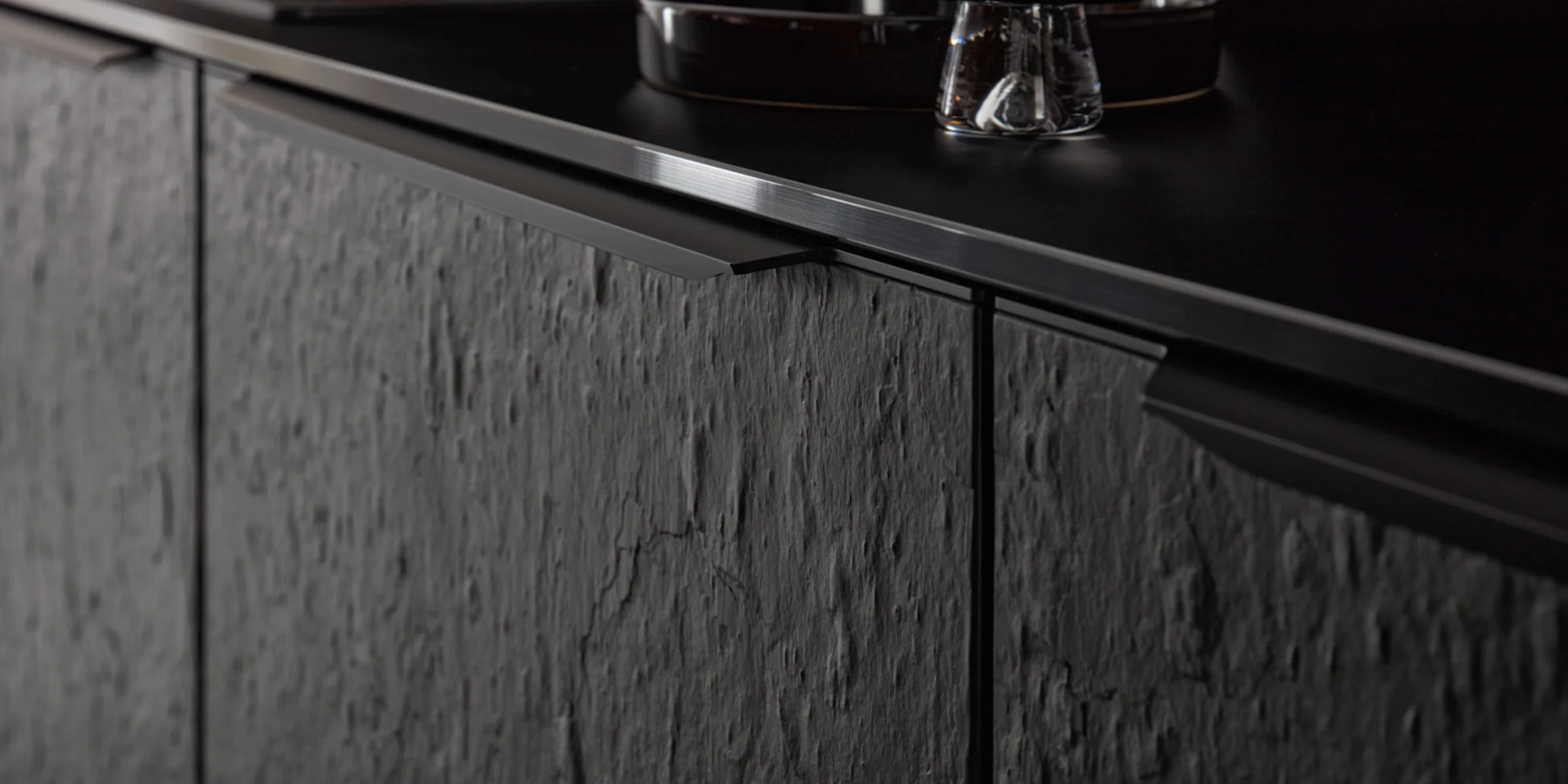 Eine moderne Küche mit dunklen, strukturierten Fronten und eleganten Details von Nolte Küchen.