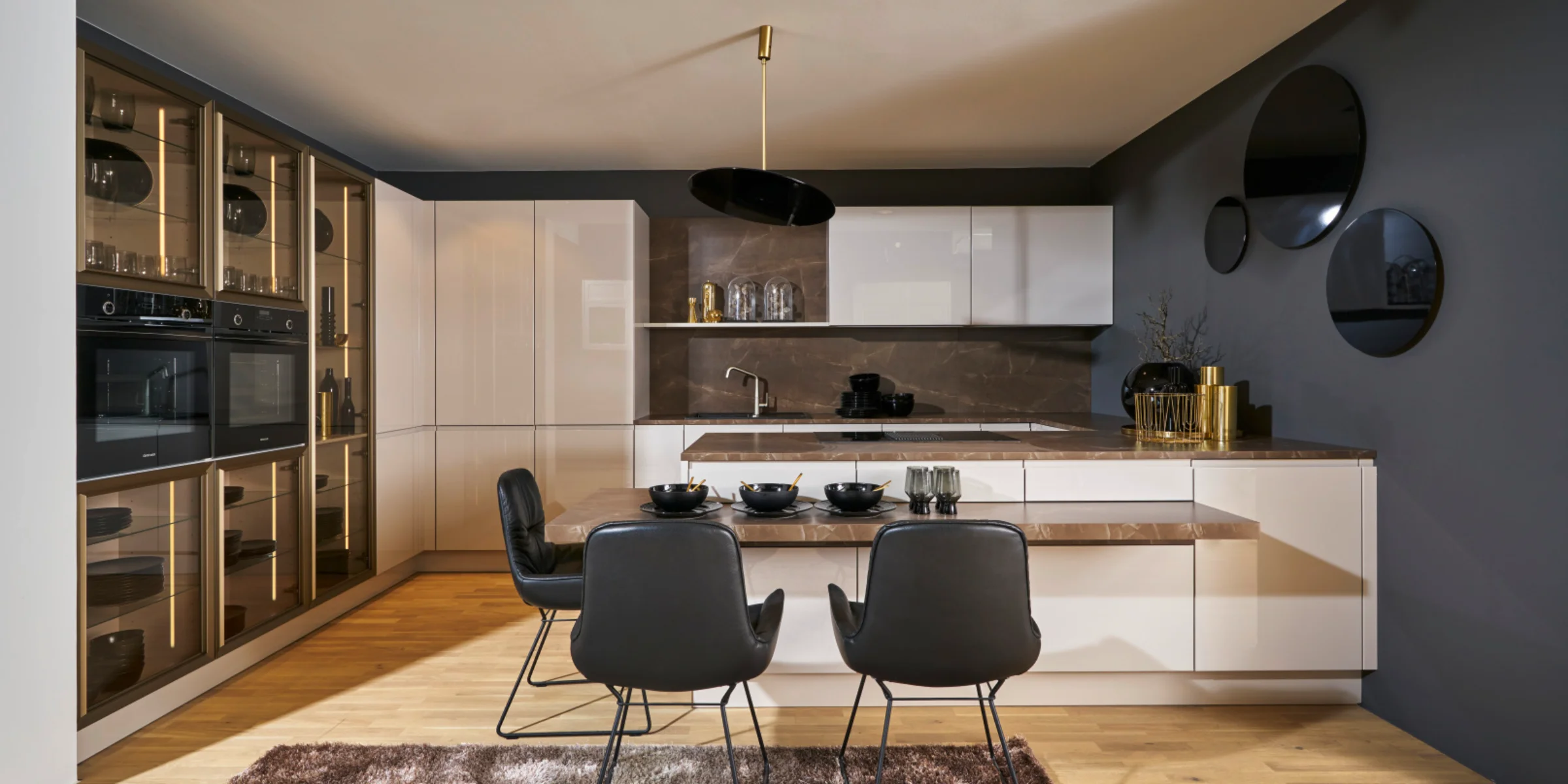 Eine moderne Küche mit schwarzem Esstisch und Stühlen, eleganten Schränken und Dekorationen von Nolte Küchen.