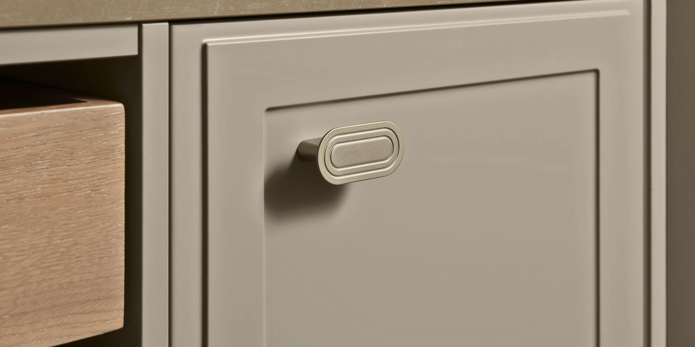 Eine Küchenschranktür mit stilvollem Griff und Holzschubladen von Nolte Küchen.