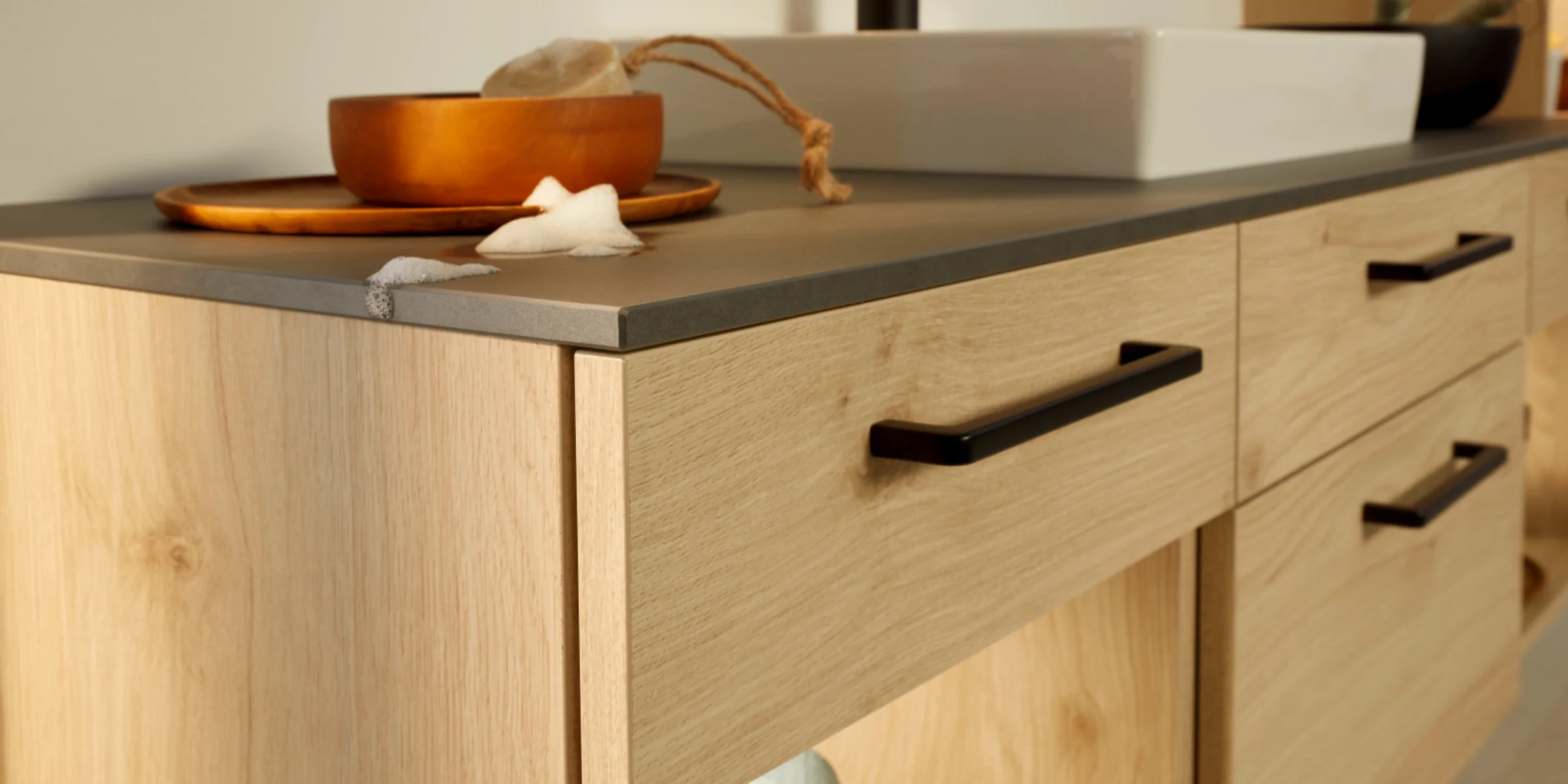 Ein modernes Badezimmer mit Holzschränken und Waschbecken, präsentiert von Nolte SPA.