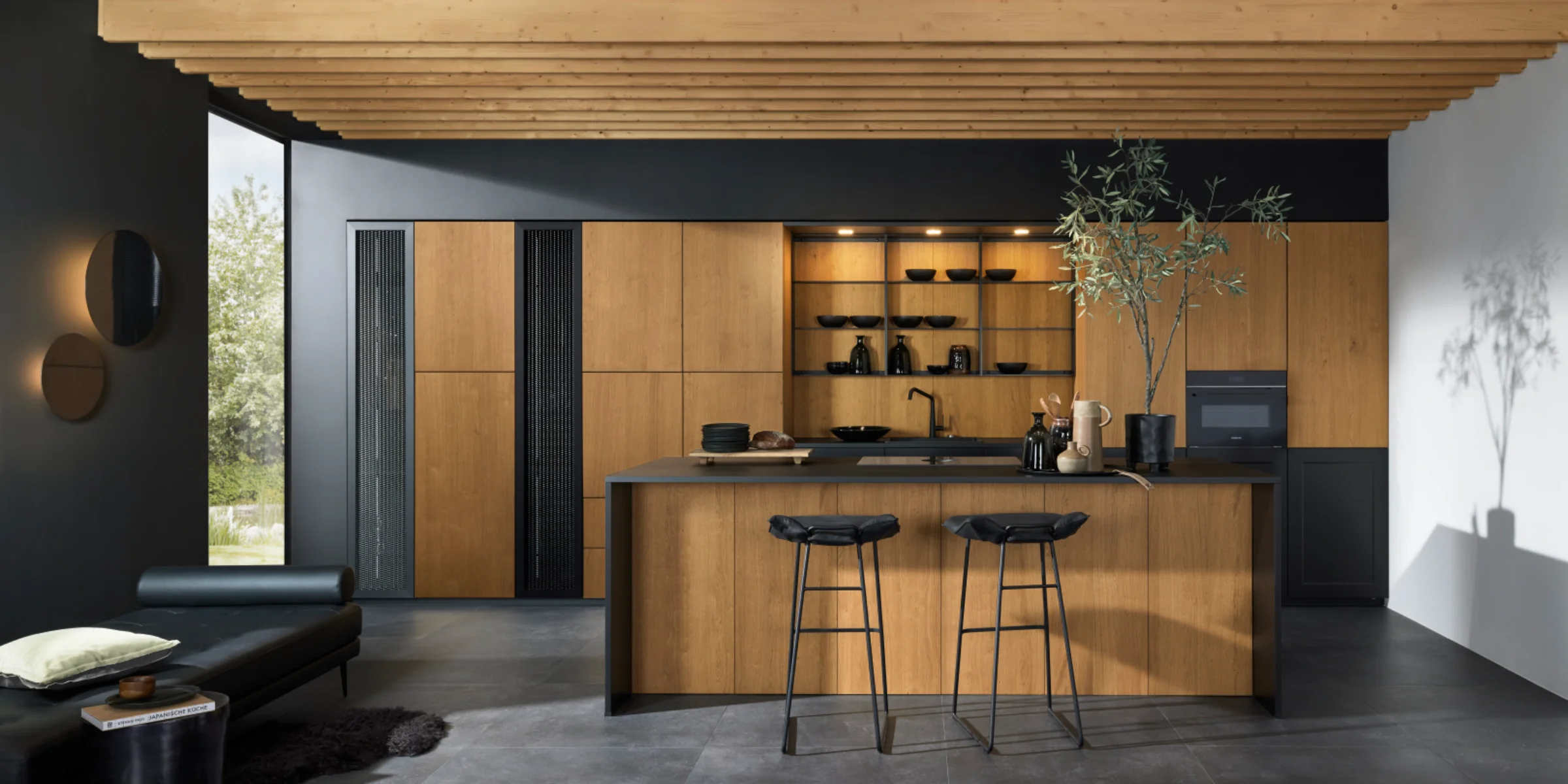 Moderne Nolte Küche mit der exklusiven Echtholz-Front neoNATURE in Eiche Cottage. Die warme Holzoptik wird durch schwarze Akzente und offene Regale stilvoll ergänzt. Die Kücheninsel mit Sitzbereich und das durchdachte Lichtkonzept schaffen ein wohnliches Ambiente mit natürlicher Eleganz.