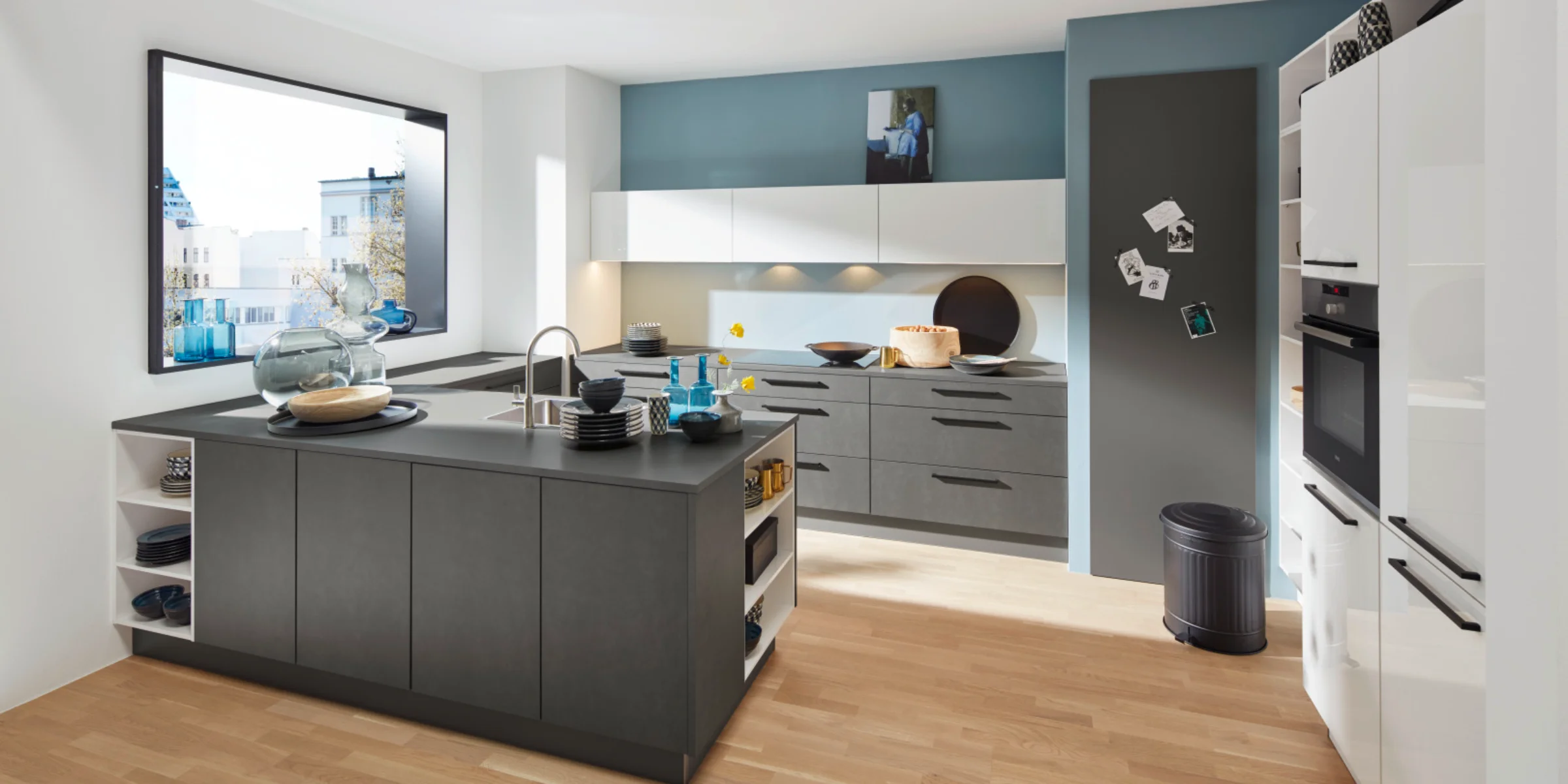 Moderne Küche mit Kochinsel und grauen Schränken in hellem Raum, Nolte Küchen.