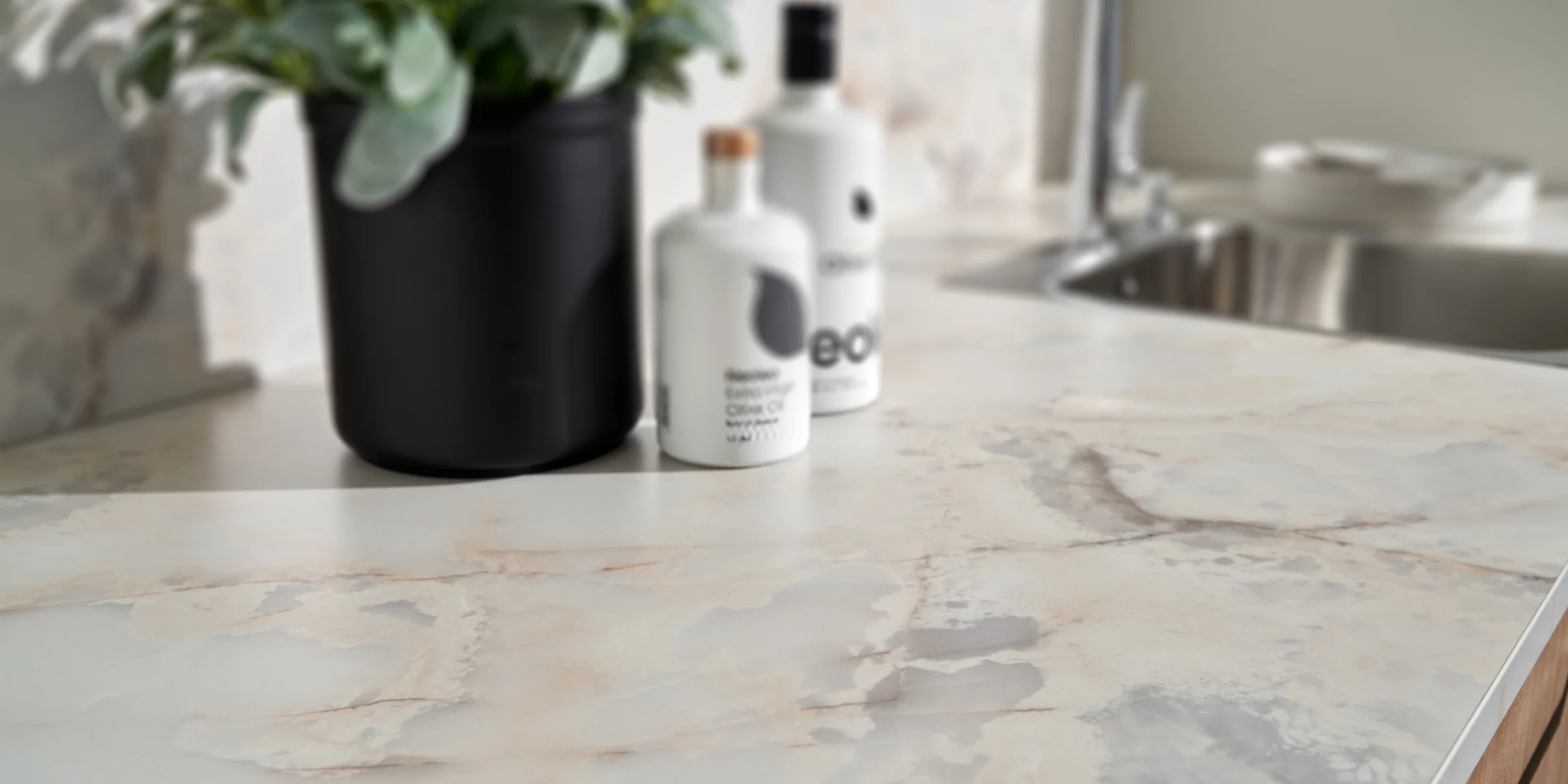 Eine stilvolle Küchenarbeitsplatte mit Pflanzen und Seifenspendern, Nolte Küchen.