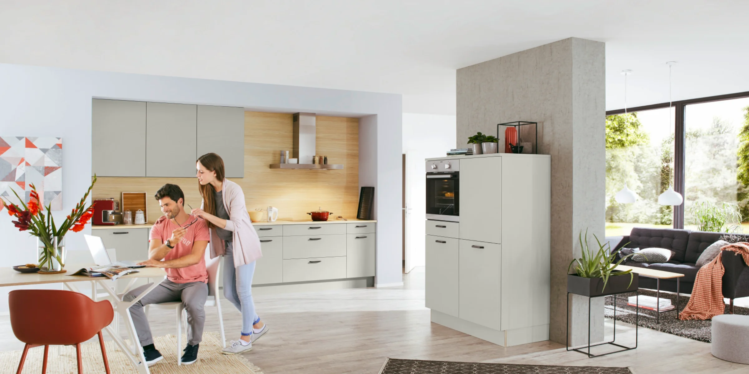 Eine moderne Küche mit Esstisch, an dem ein Paar sitzt, von Nolte Küchen.