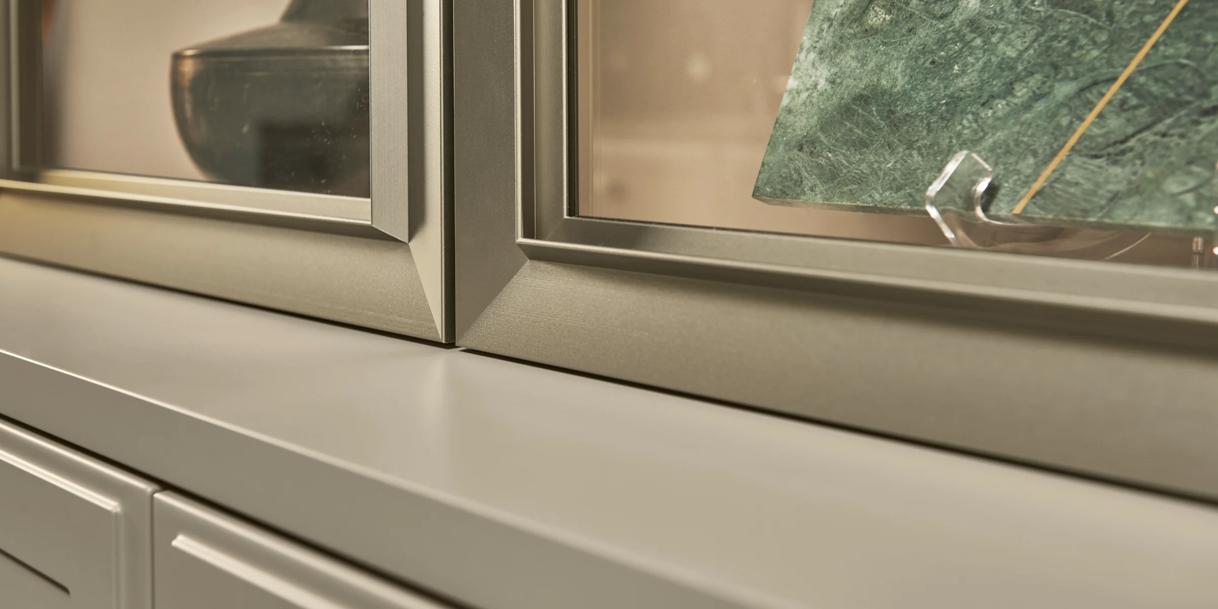 Eine Nahaufnahme eines Schrankes mit einer Vase und einer grünen Platte, Teil von Nolte Living.