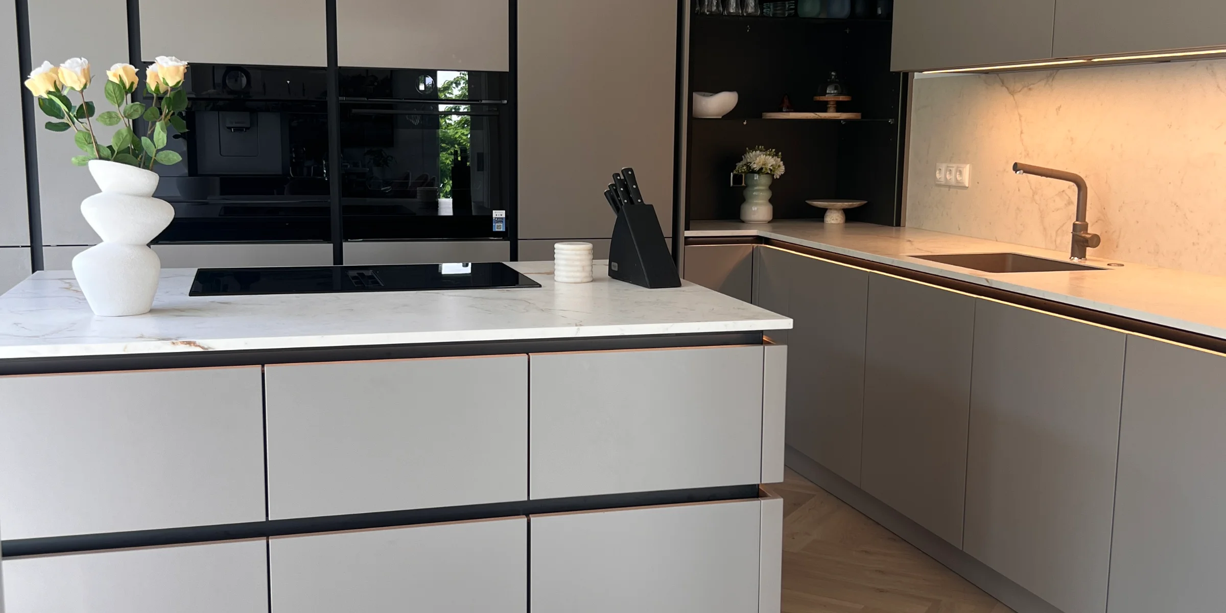 Eine moderne Küche mit grauen Schränken und einer zentralen Insel. Nolte Küchen.