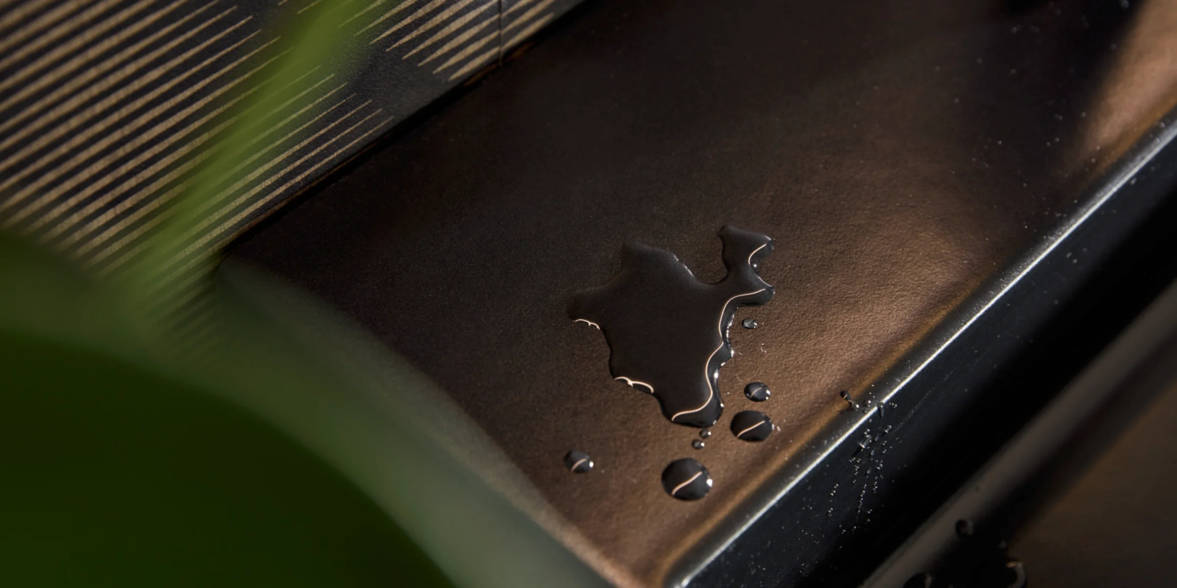 Wasser tropft auf eine schwarze Oberfläche in einem stilvollen Bad von Nolte SPA.