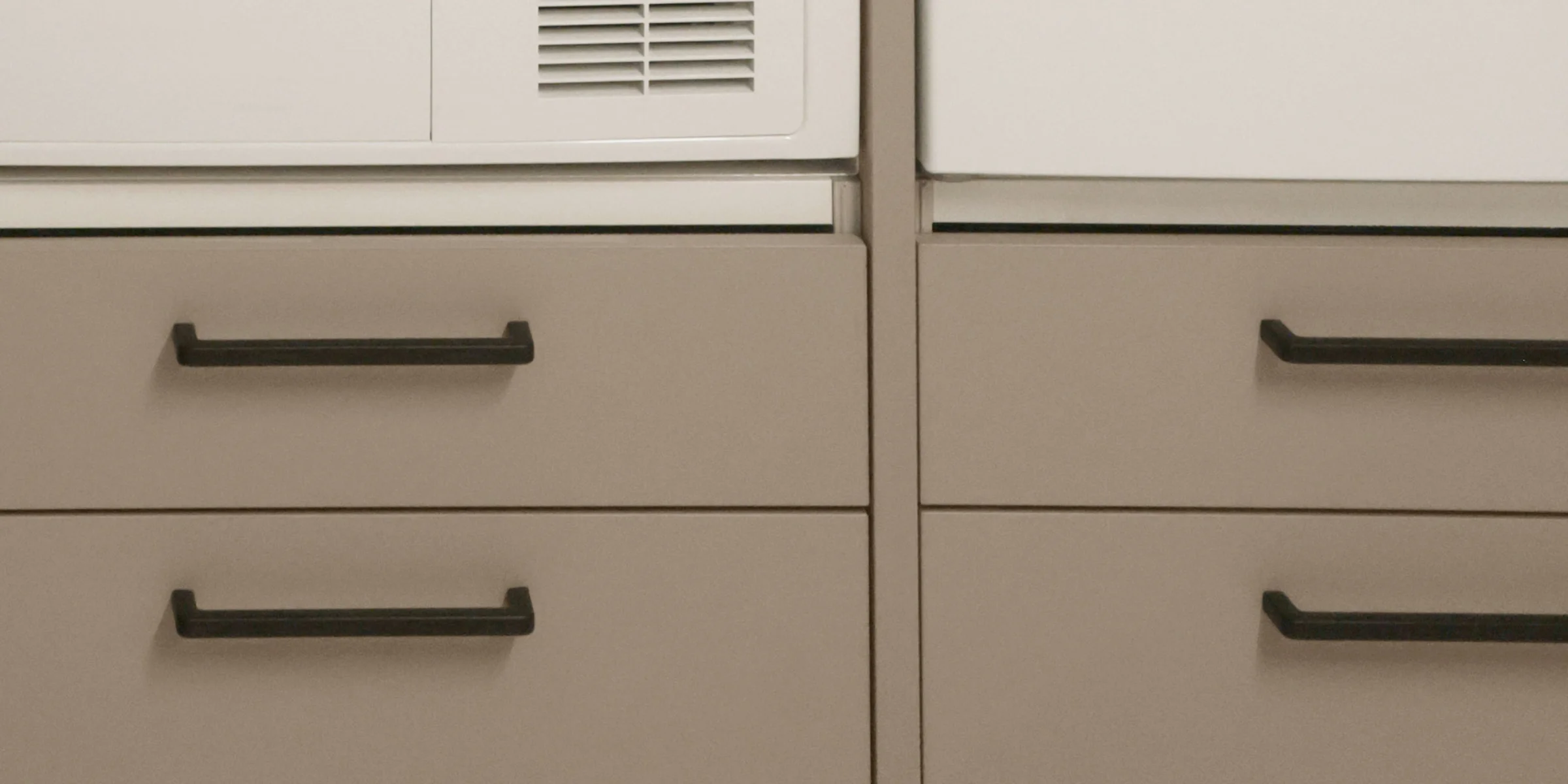 Ein Hauswirtschaftsraum mit Schränken und Geräten von Nolte Hauswirtschaftsräume.