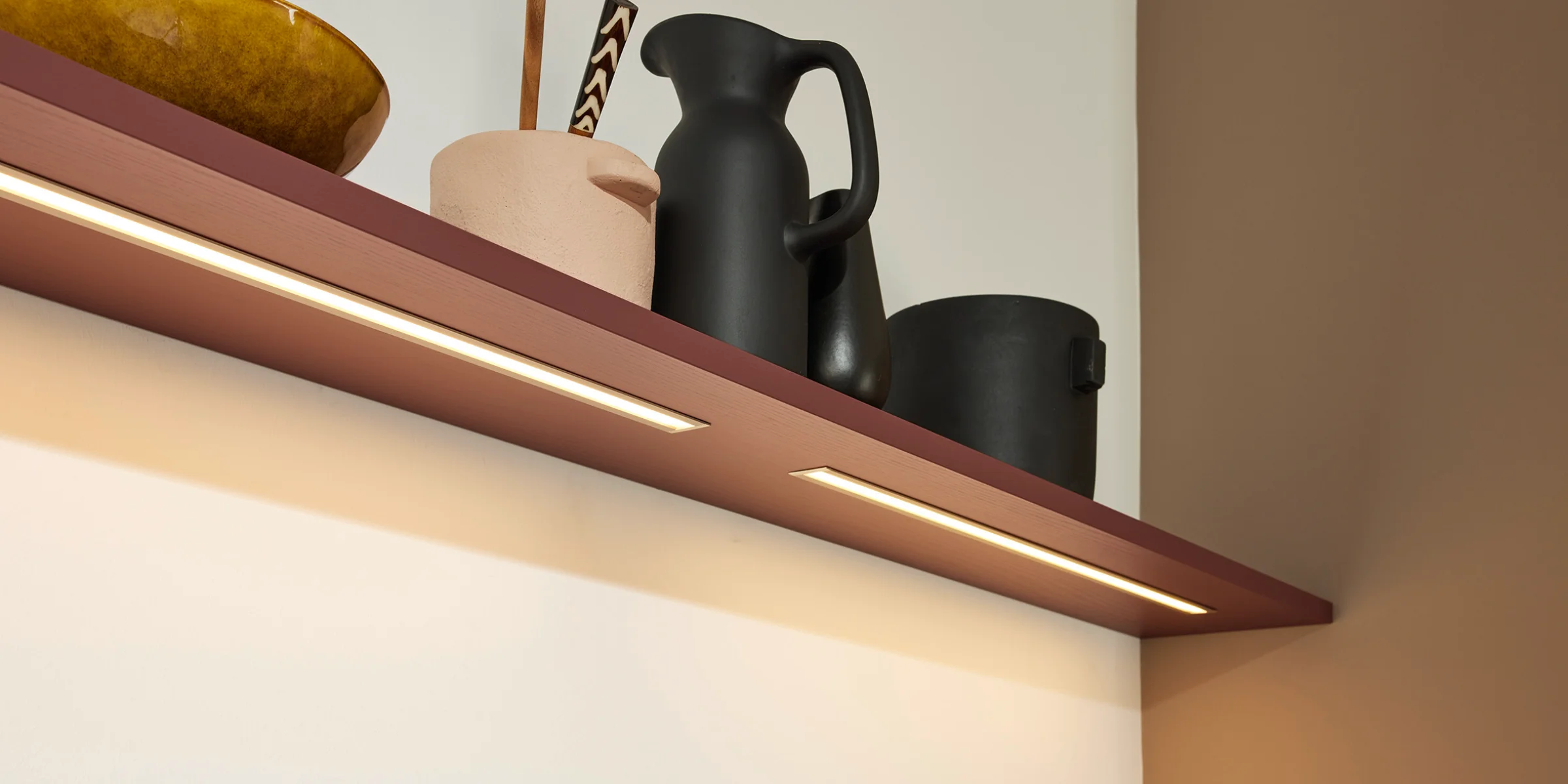 Ein Regal mit dekorativen Gefäßen steht in einem modernen Raum, Nolte Living.