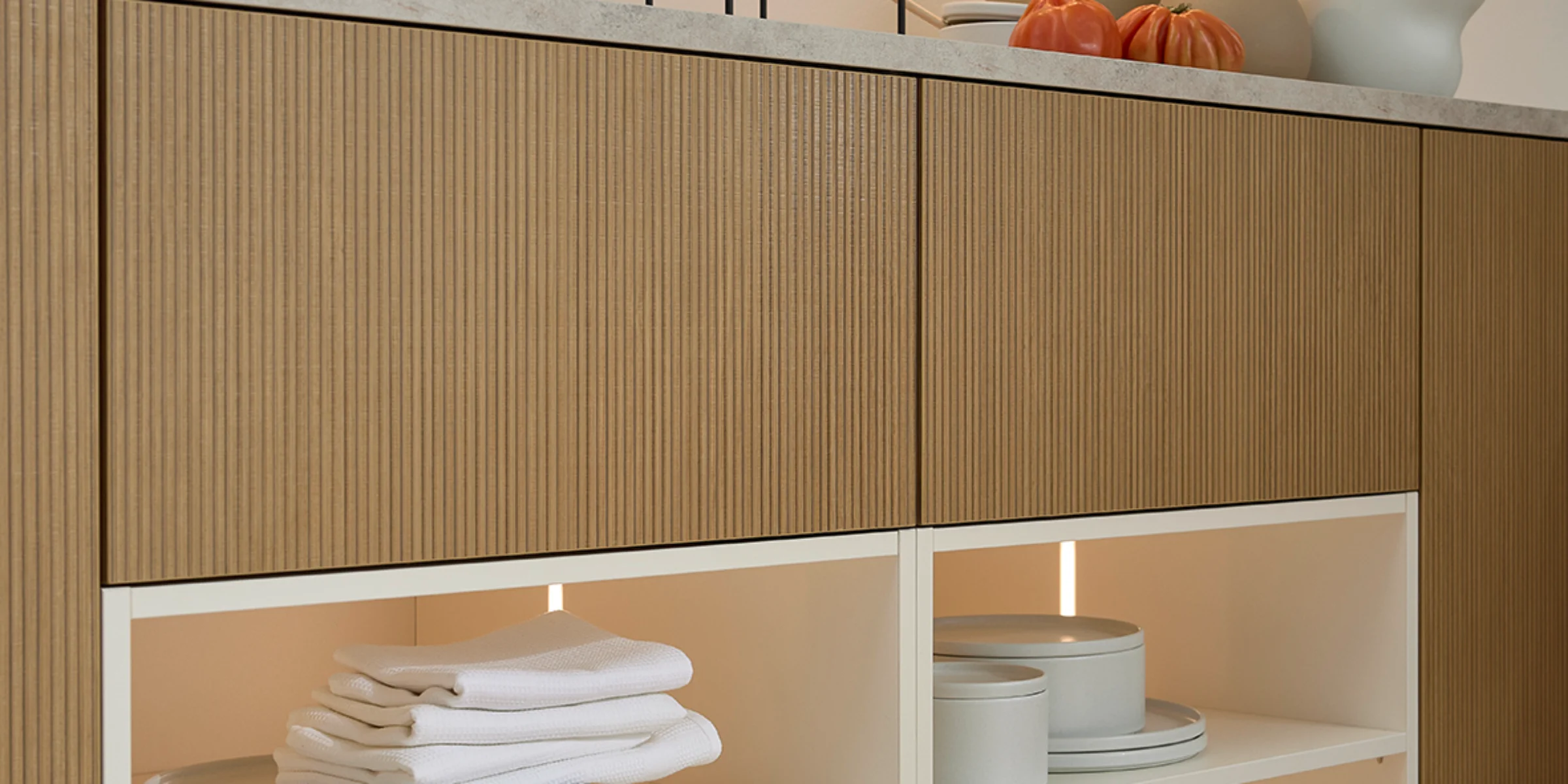 Ein stilvolles Regal mit Geschirr und Dekorationen in einem modernen Raum von Nolte Living.