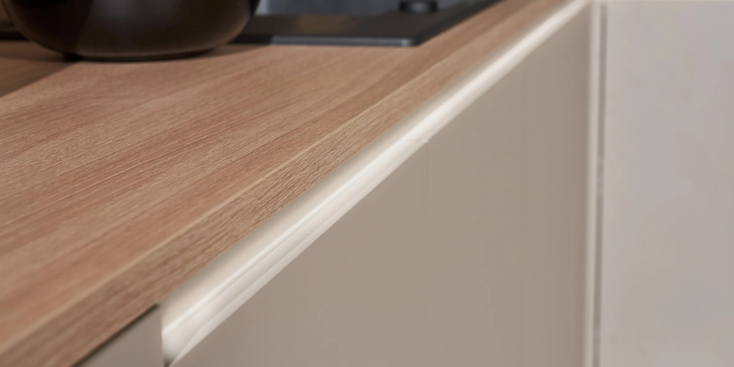 Eine moderne Küche mit Holzarbeitsplatte und hellen Schränken von Nolte Küchen.