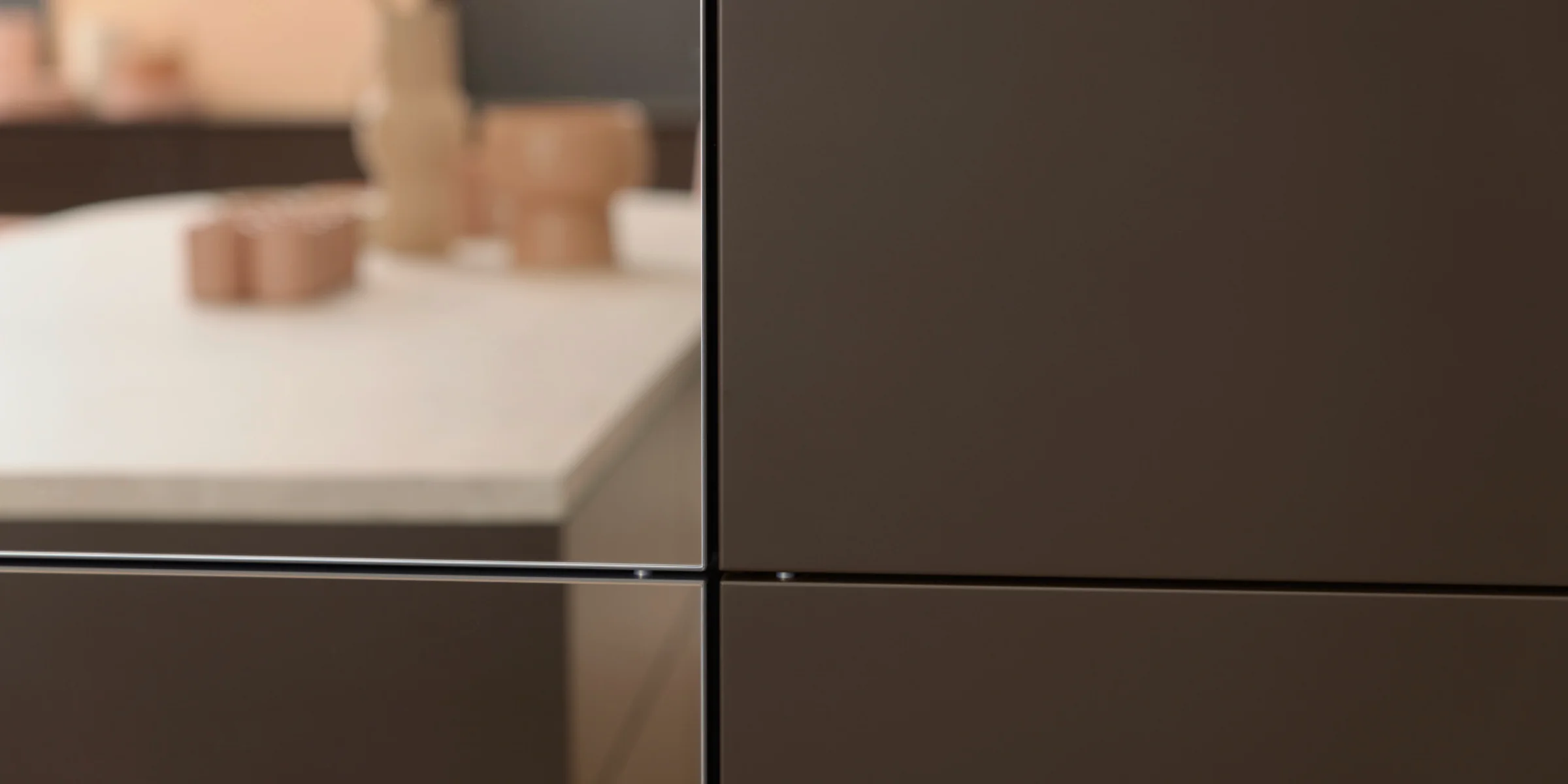 Eine moderne Küche mit dunklen Schränken und heller Arbeitsplatte, Nolte Küchen.