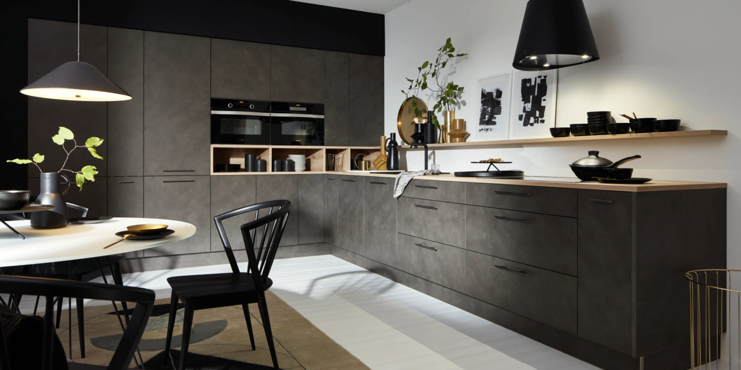 Eine moderne Küche mit dunklen Schränken und stilvoller Beleuchtung, gestaltet von Nolte Küchen.