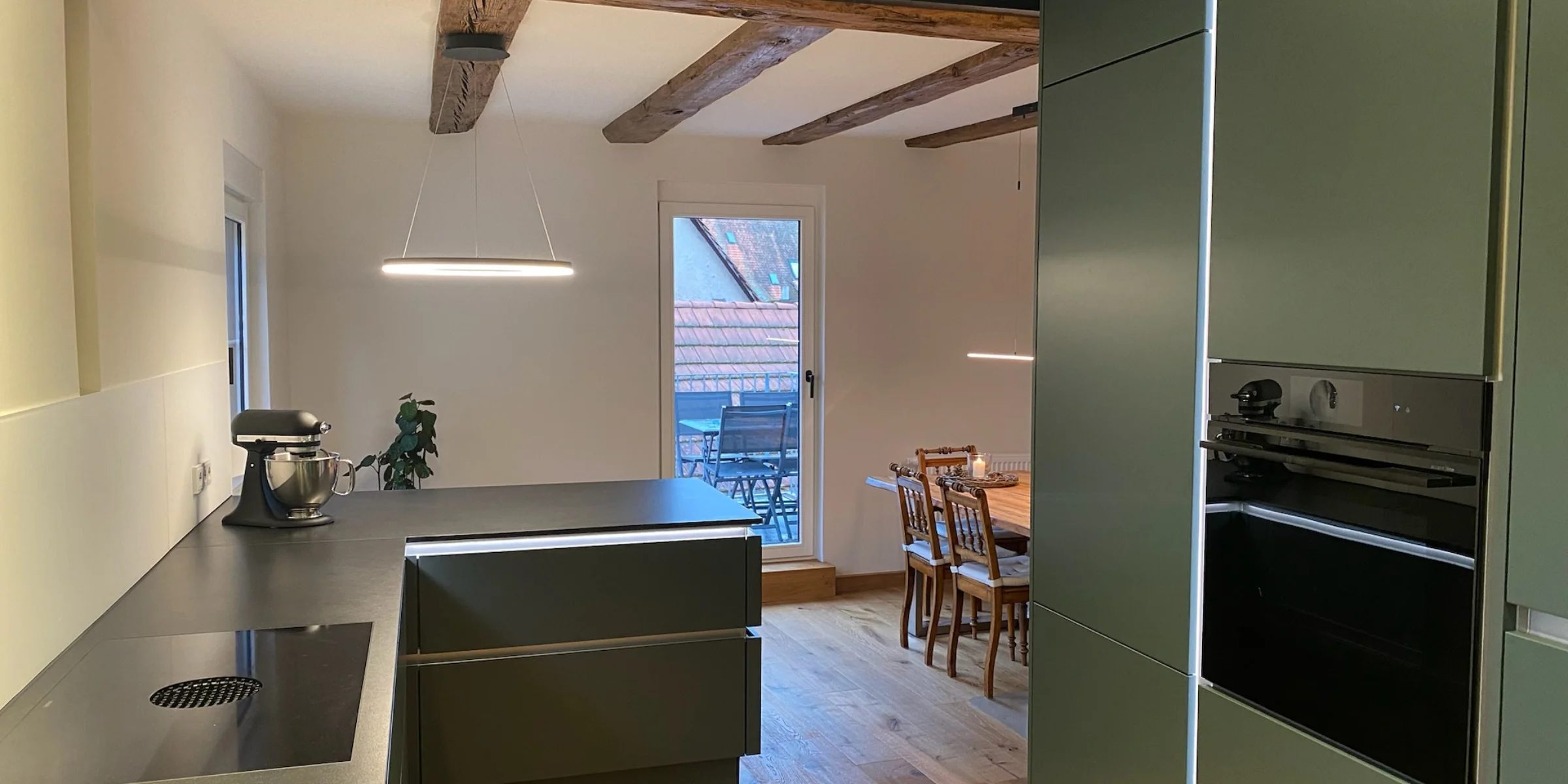 Moderne Küche mit Holzdetails und Essbereich, präsentiert von Nolte Küchen.